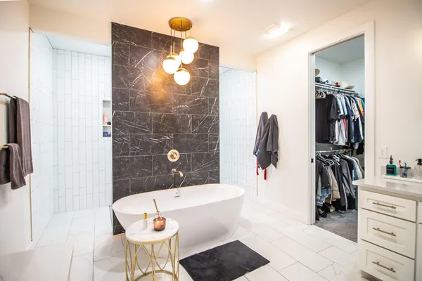 a bathroom with a tub sink and mirror