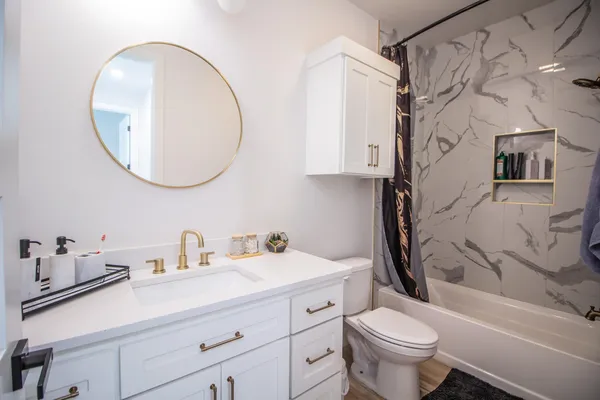 a bathroom with a sink a toilet and a mirror