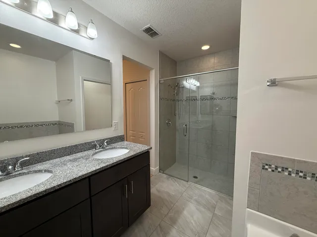 a bathroom with a granite countertop sink mirror and shower