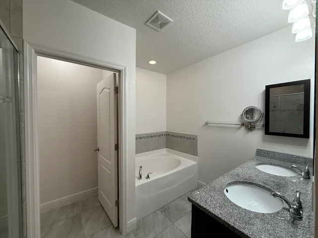 a bathroom with a granite countertop sink toilet and shower