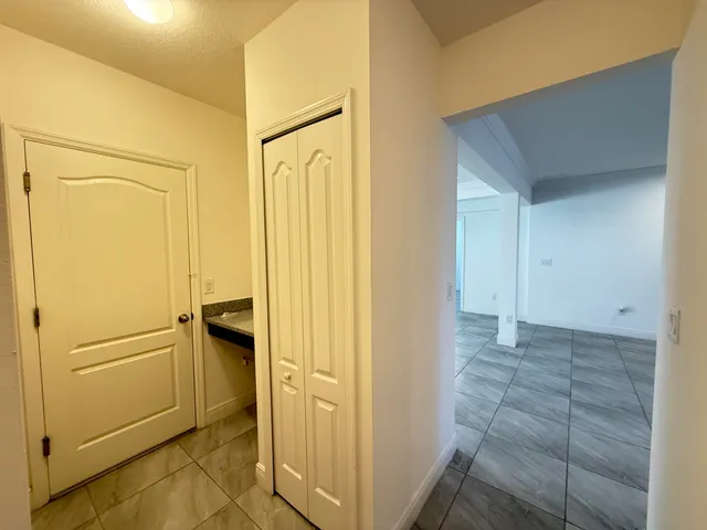 a view of a hallway with closet and wooden floor
