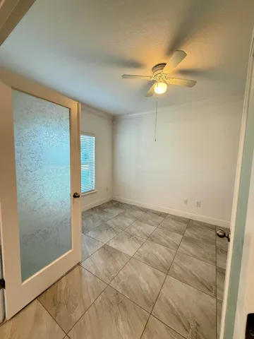 an empty room with closet and fan