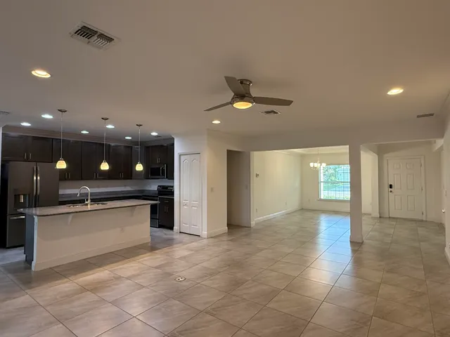 a view of a kitchen with a sink and refrigerator