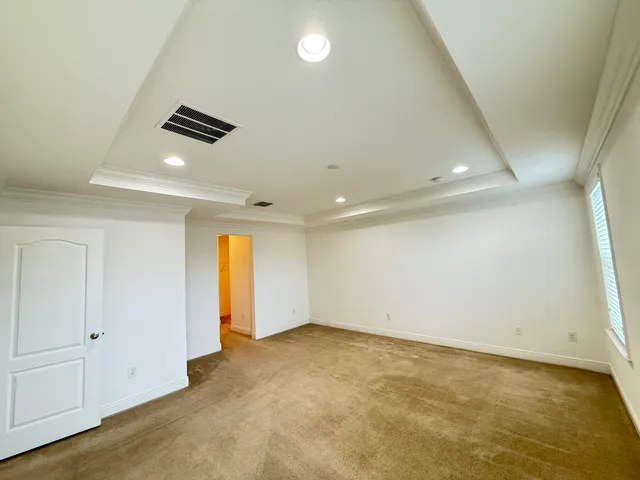 en empty room with windows and ceiling fan