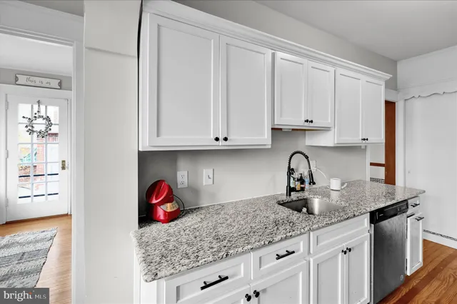 a kitchen with stainless steel appliances granite countertop a sink dishwasher and cabinets with wooden floor