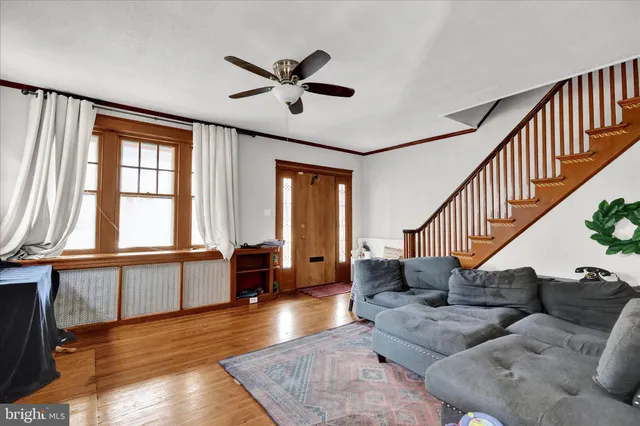 a living room with furniture wooden floor and a large window