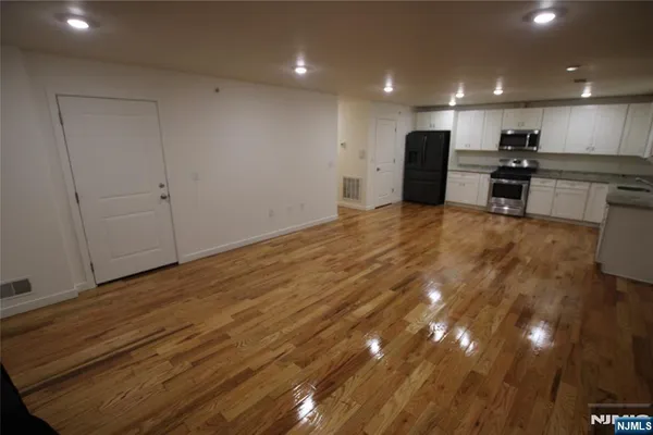 a view of kitchen with refrigerator and a sink