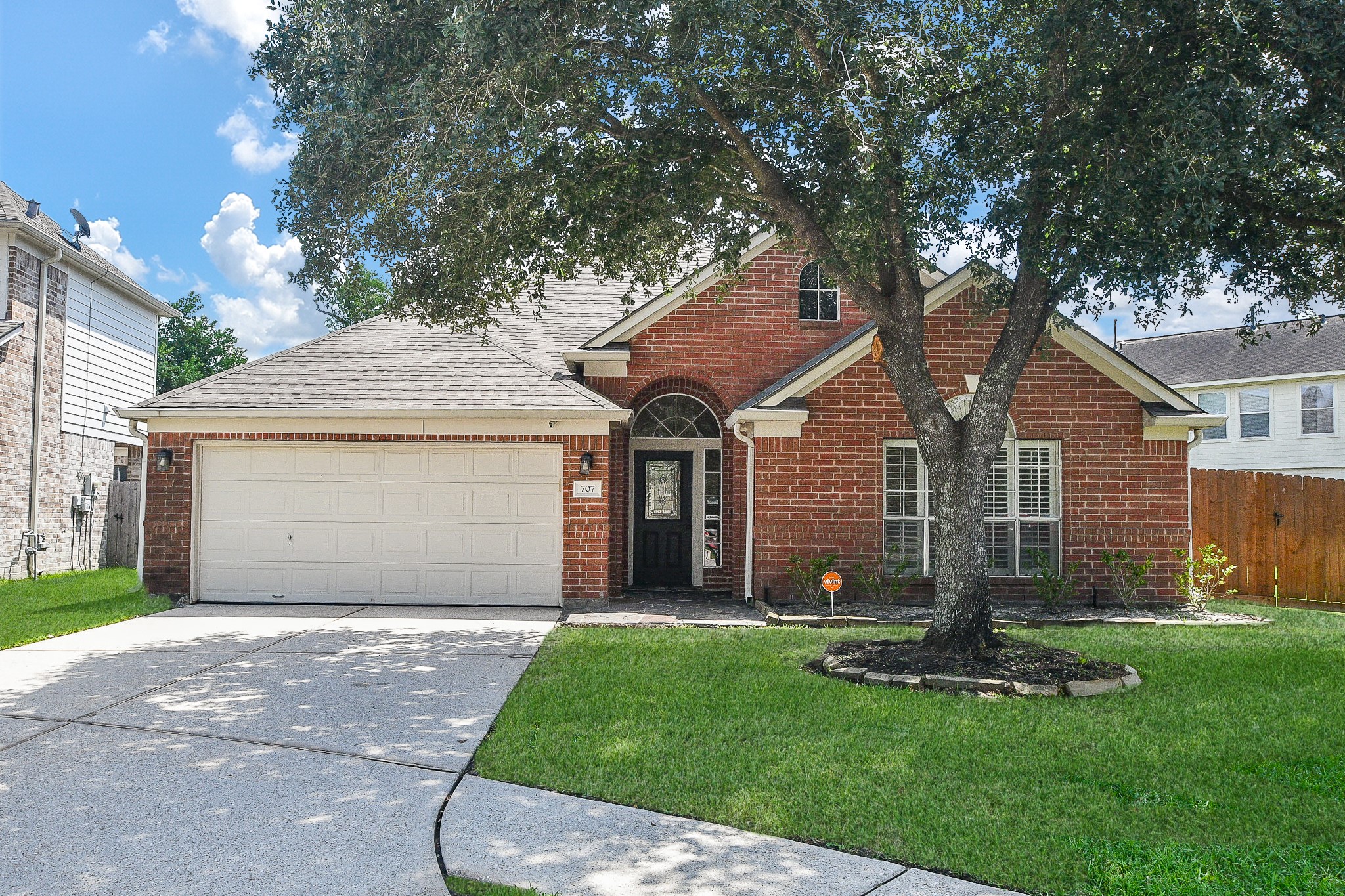 707 New Pines Drive Spring, TX 77373 - Photo 2 of 33 a front view of a house with a garden and yard