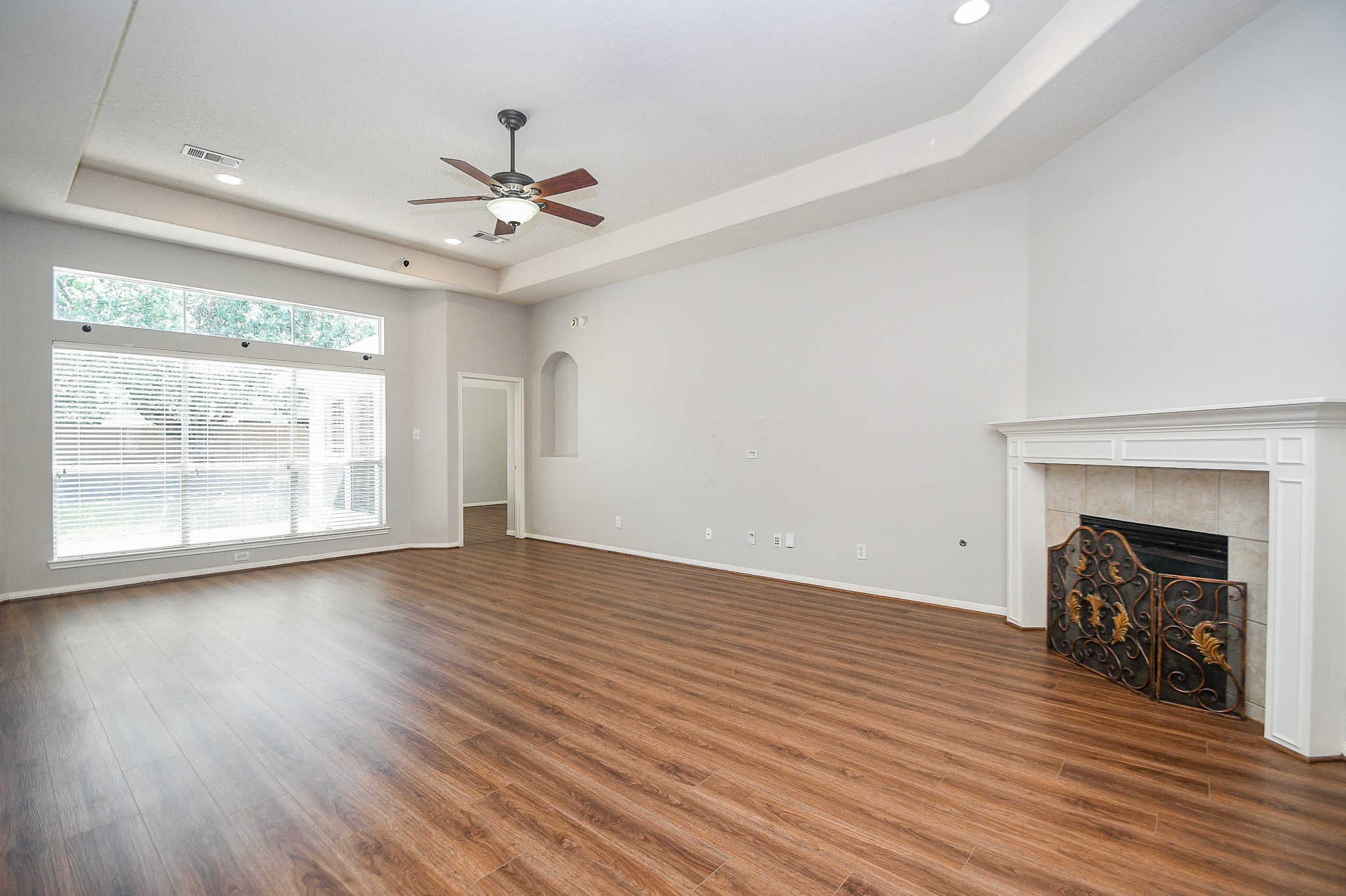 707 New Pines Drive Spring, TX 77373 - Photo 7 of 33 an empty room with wooden floor fireplace and windows