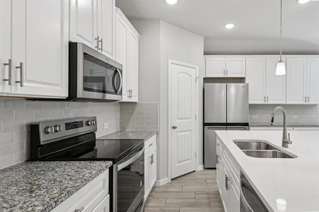 a kitchen with stainless steel appliances granite countertop a sink stove and refrigerator