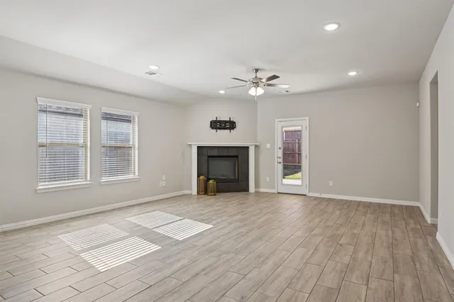a view of an empty room with a fireplace and a window