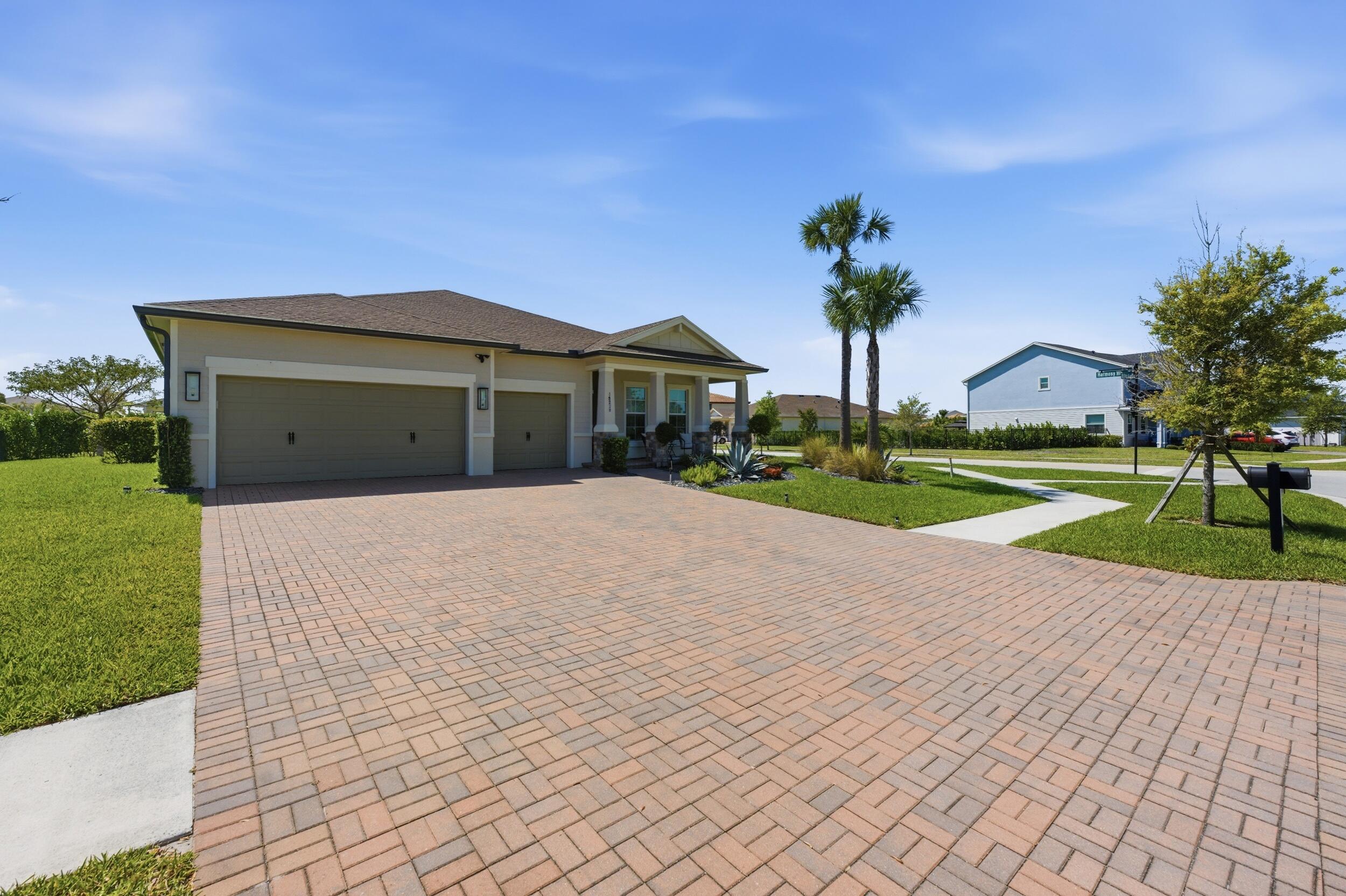 19230 Rolling Acres Road Loxahatchee, FL 33470 - Photo 44 of 58 a front view of a house with a yard and potted plants