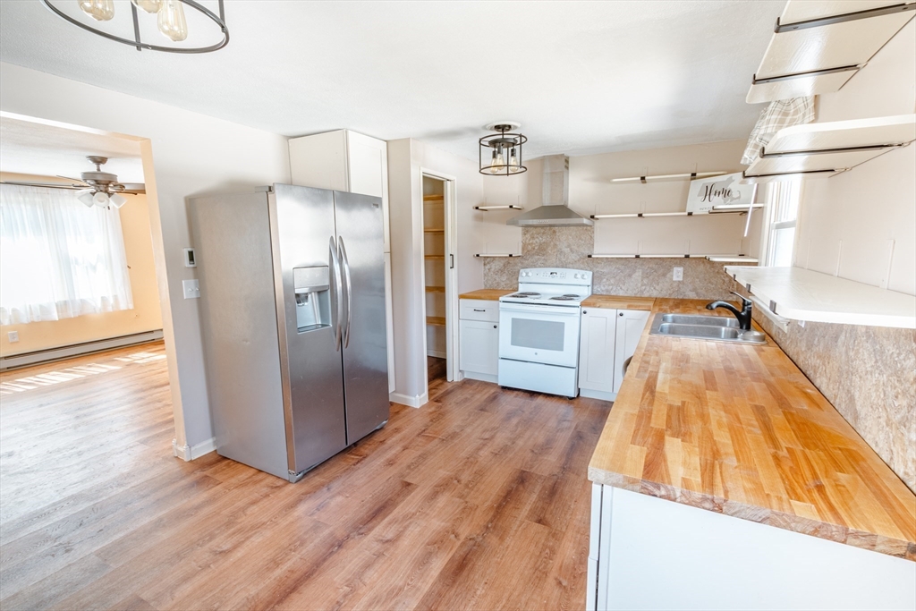 16 Meadow Road Ware, MA 01082 - Photo 3 of 24 a kitchen with kitchen island a counter top space a stove and wooden floor
