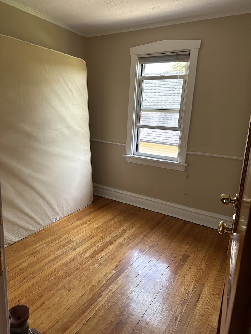 192 Waubansee Road Riverside, IL 60546 - Photo 12 of 19 a view of an empty room with wooden floor and a window