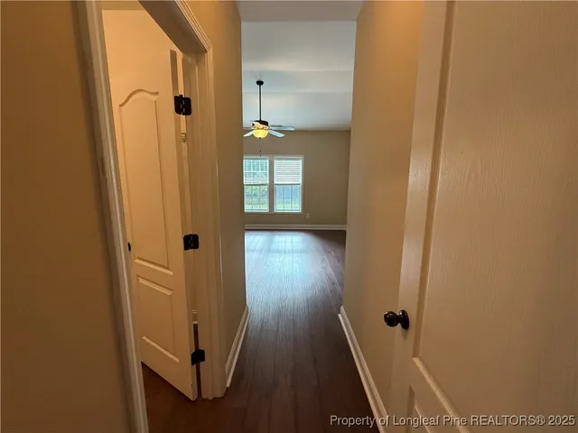 a view of a hallway with wooden floor