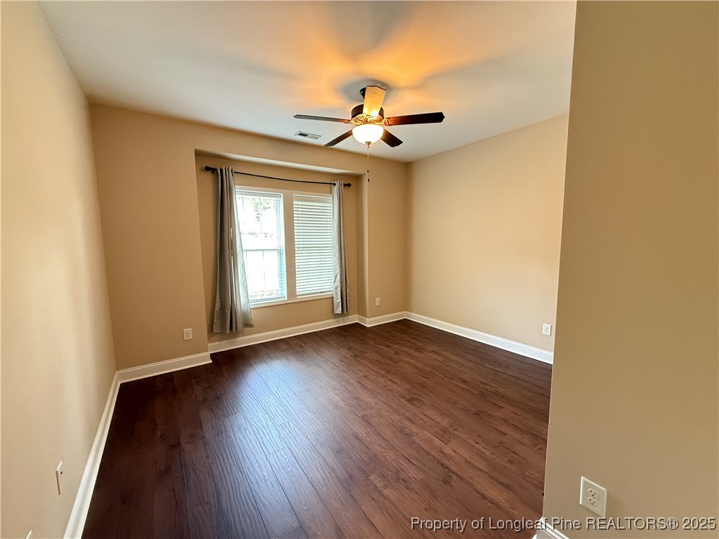 Undisclosed Address Spring Lake, NC 28390 - Photo 19 of 22 an empty room with wooden floor fan and windows