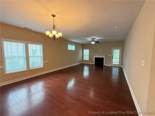 a view of a livingroom with wooden floor and a ceiling fan