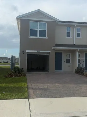 a front view of a house with a yard and a garage