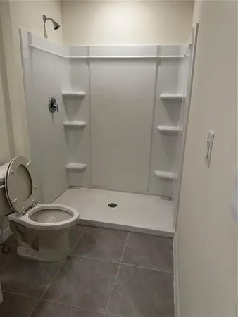 a bathroom with a toilet and a shower