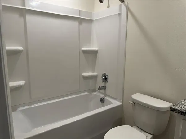 a white toilet sitting next to a bathtub