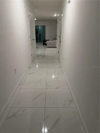 a view of a hallway to an empty room with a window