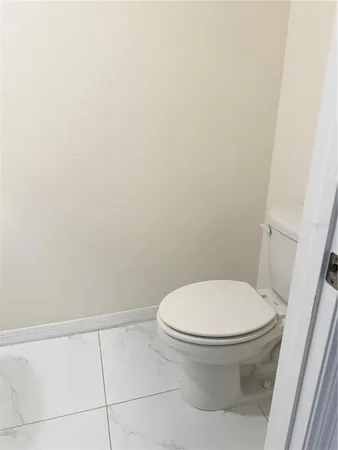 a white toilet sitting next to a white cabinet