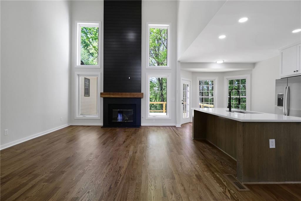 6259 Spring Lake Drive Flowery Branch, GA 30542 - Photo 1 of 35 an empty room with wooden floor a fireplace and windows