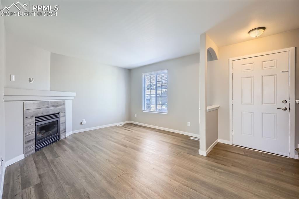 359 Ellers Grove Colorado Springs, CO 80916 - Photo 4 of 27 Foyer featuring wood-type flooring and a tiled fireplace