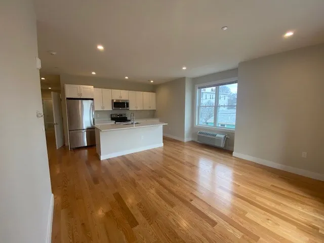 a view of kitchen with wooden floor and electronic appliances