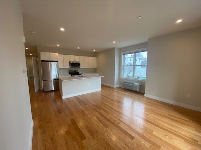 a view of kitchen with wooden floor and electronic appliances