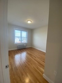 208 Neponset Valley Parkway, Unit 5 Boston, MA 02136 - Photo 3 of 9 an empty room with wooden floor and windows