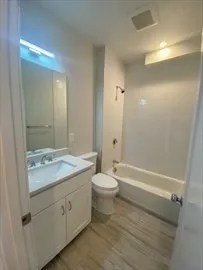 a bathroom with a granite countertop sink toilet and shower