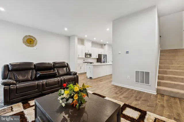 a living room with furniture and a kitchen area