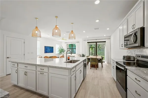 a kitchen with counter top space sink stove and microwave