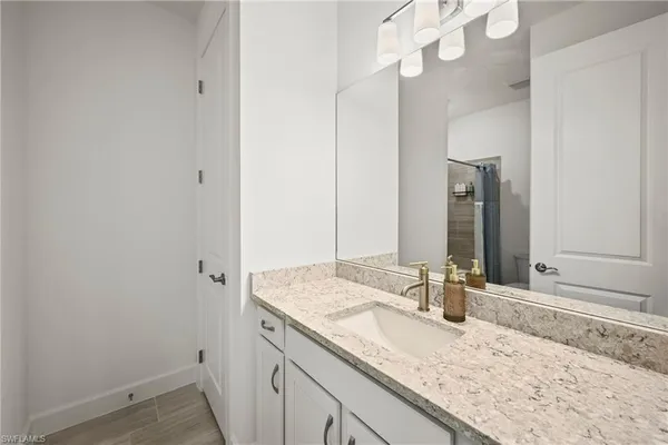a bathroom with a granite countertop sink and a mirror