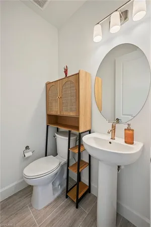 a bathroom with a toilet a sink and mirror