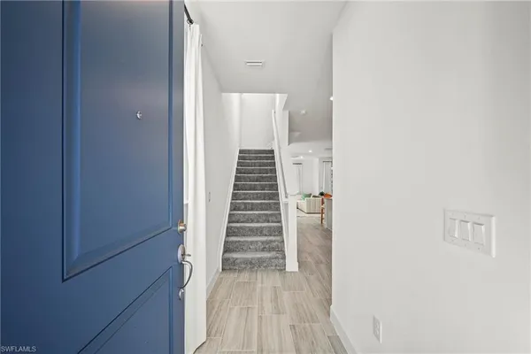 a view of a hallway with wooden floor and stairs