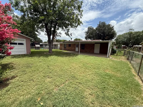a view of a house with a yard and sitting area