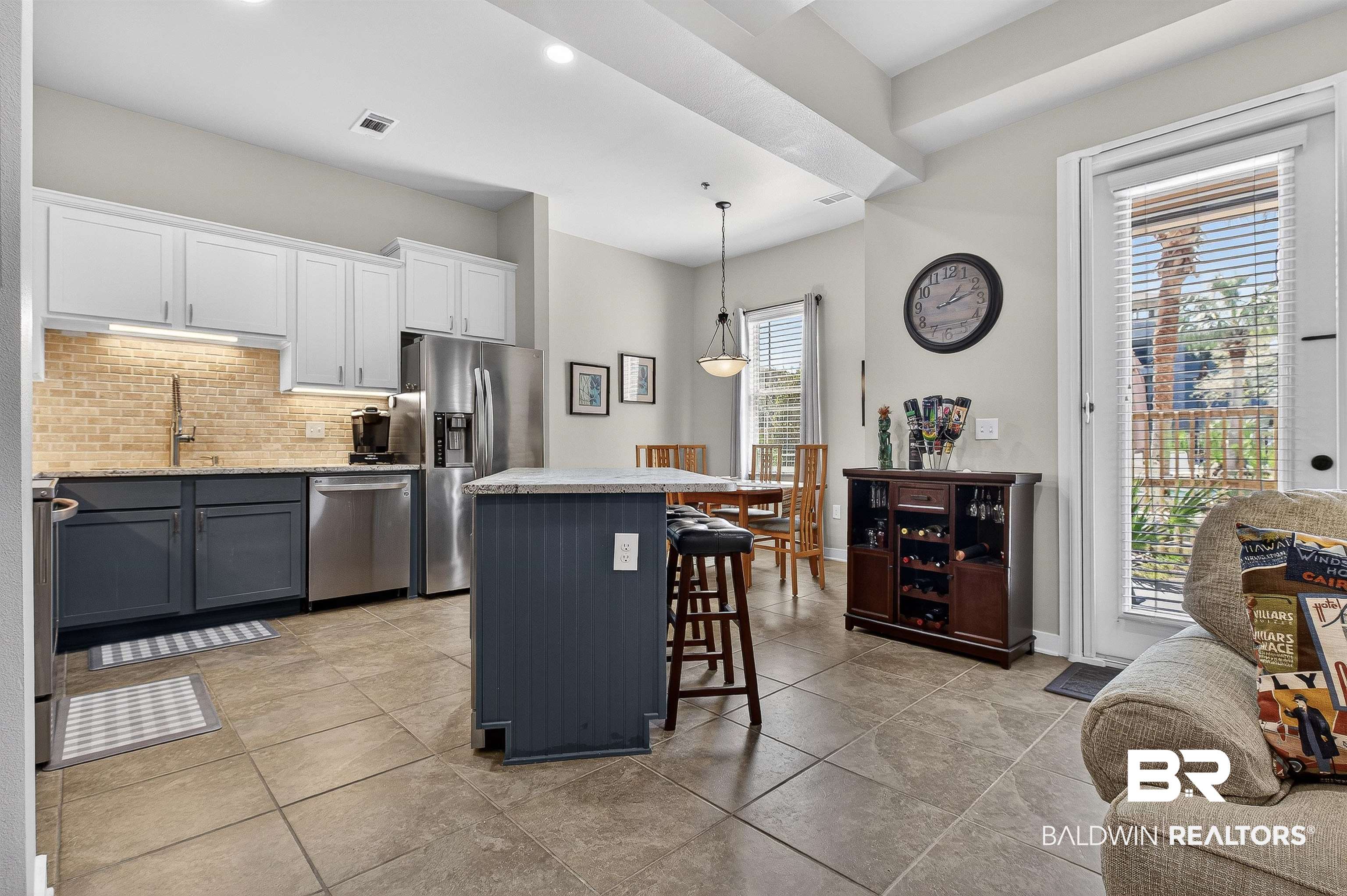 1430 West Regency Road, Unit I102 Gulf Shores, AL 36542 - Photo 11 of 31 Kitchen featuring a center island, stainless steel appliances, pendant lighting, a breakfast bar area, and tasteful backsplash