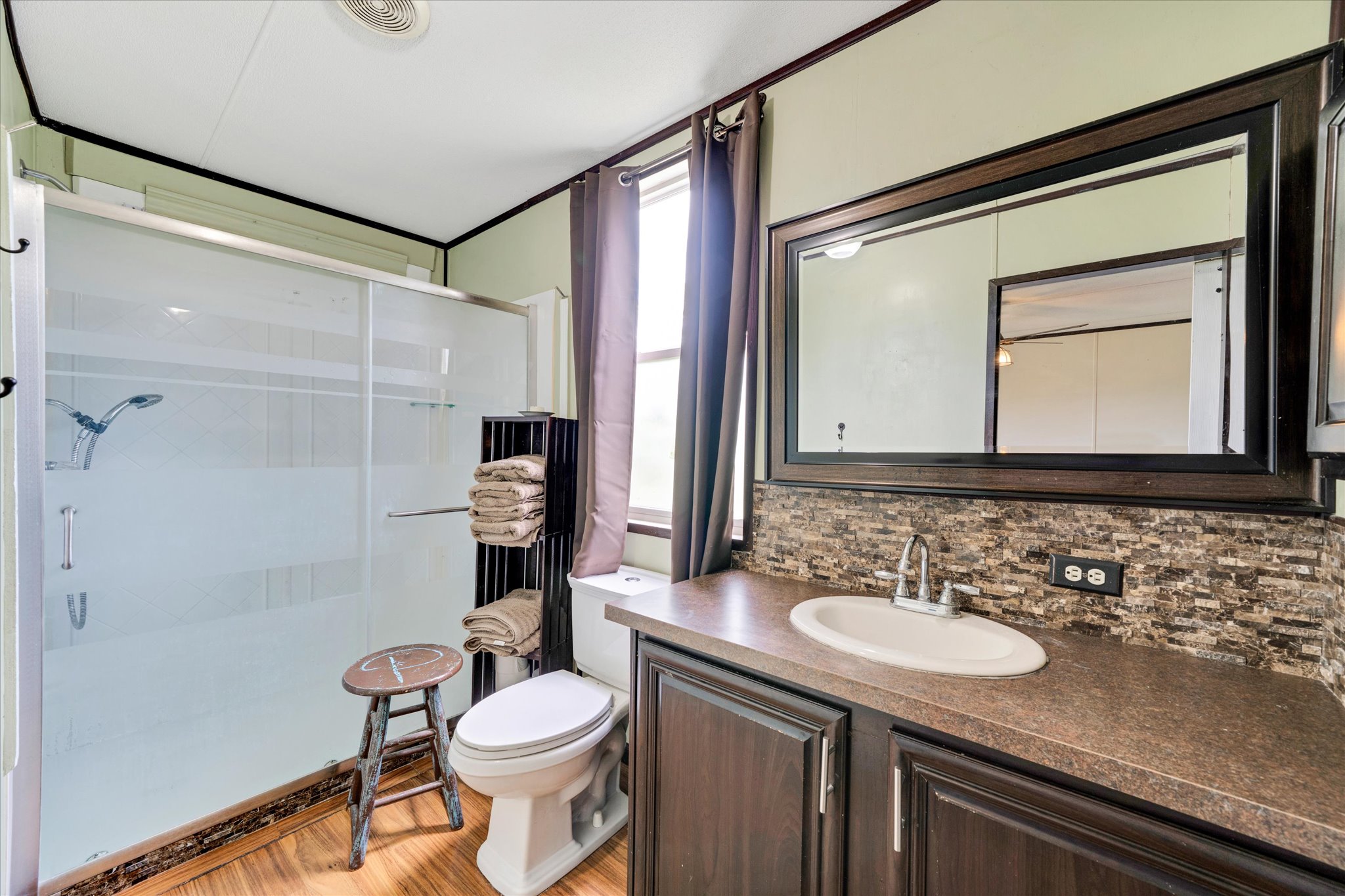 1500 Wattsville Road Luling, TX 78648 - Photo 28 of 38 A well-appointed bathroom offers a convenient shower, vanity with ample counter space, and a large mirror.