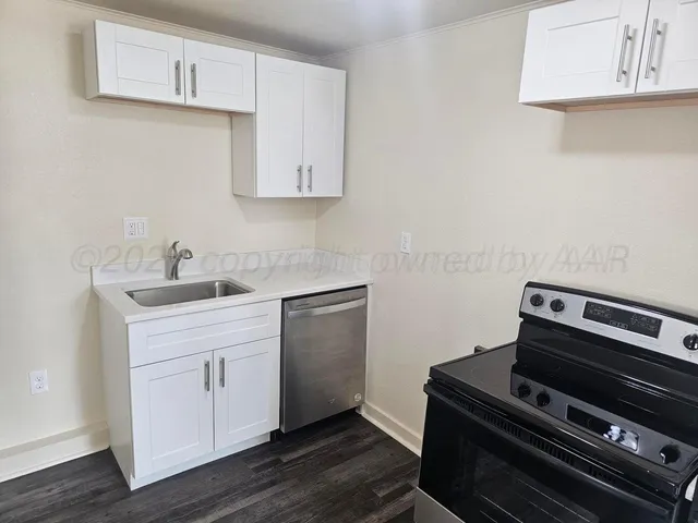 a kitchen with a stove and white cabinets