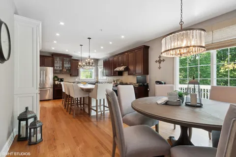 a view of a dining room with furniture a chandelier and wooden floor