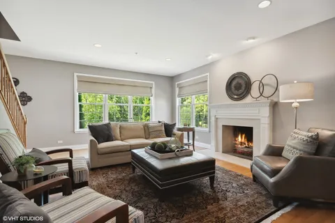 a living room with furniture a clock and a large window