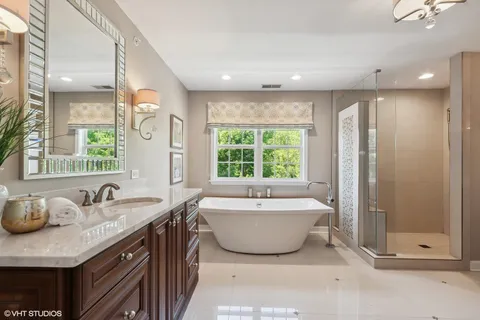 a spacious bathroom with a double vanity sink a mirror and a bathtub