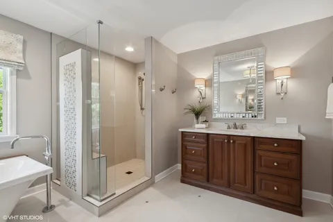 a bathroom with a double vanity sink mirror and shower