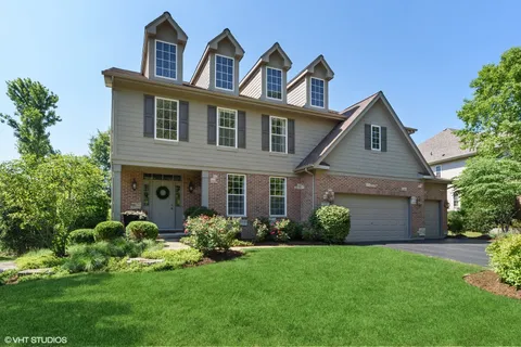 a front view of a house with a garden and plants