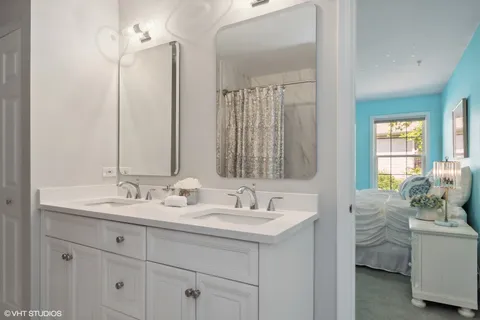 a bathroom with double vanity sink and a mirror