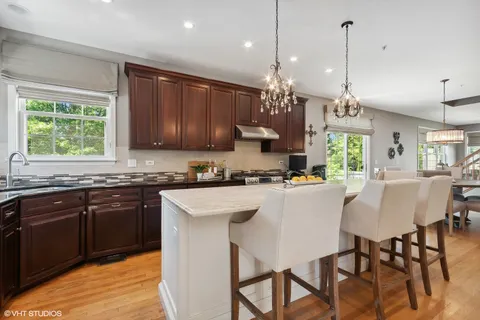 a kitchen with kitchen island a dining table chairs and a sink