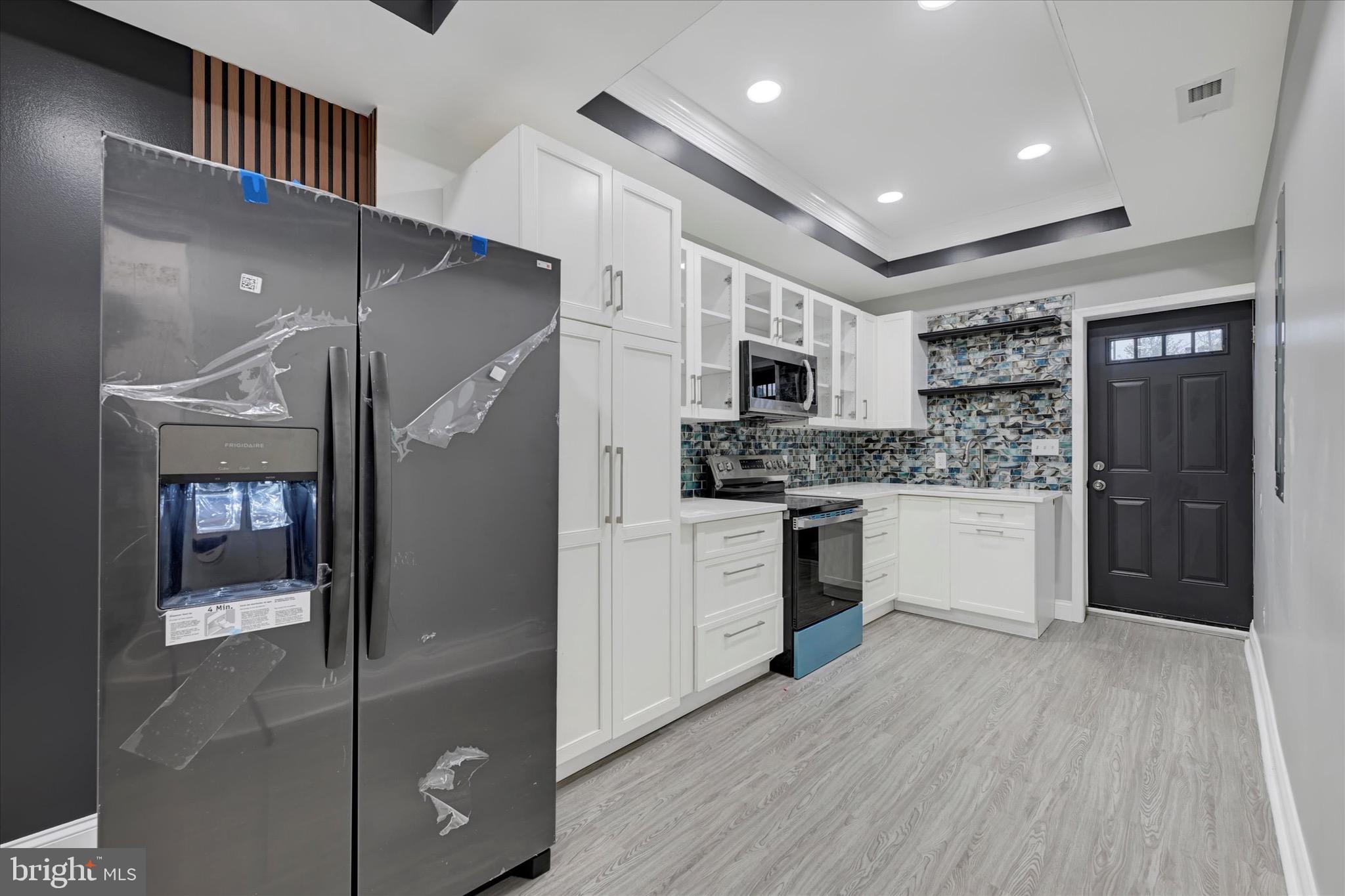 a kitchen with stainless steel appliances kitchen island granite countertop a refrigerator and a sink