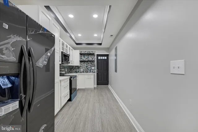 a view of a refrigerator in kitchen and cabinets